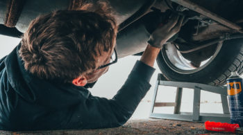 Man laying down working on a car